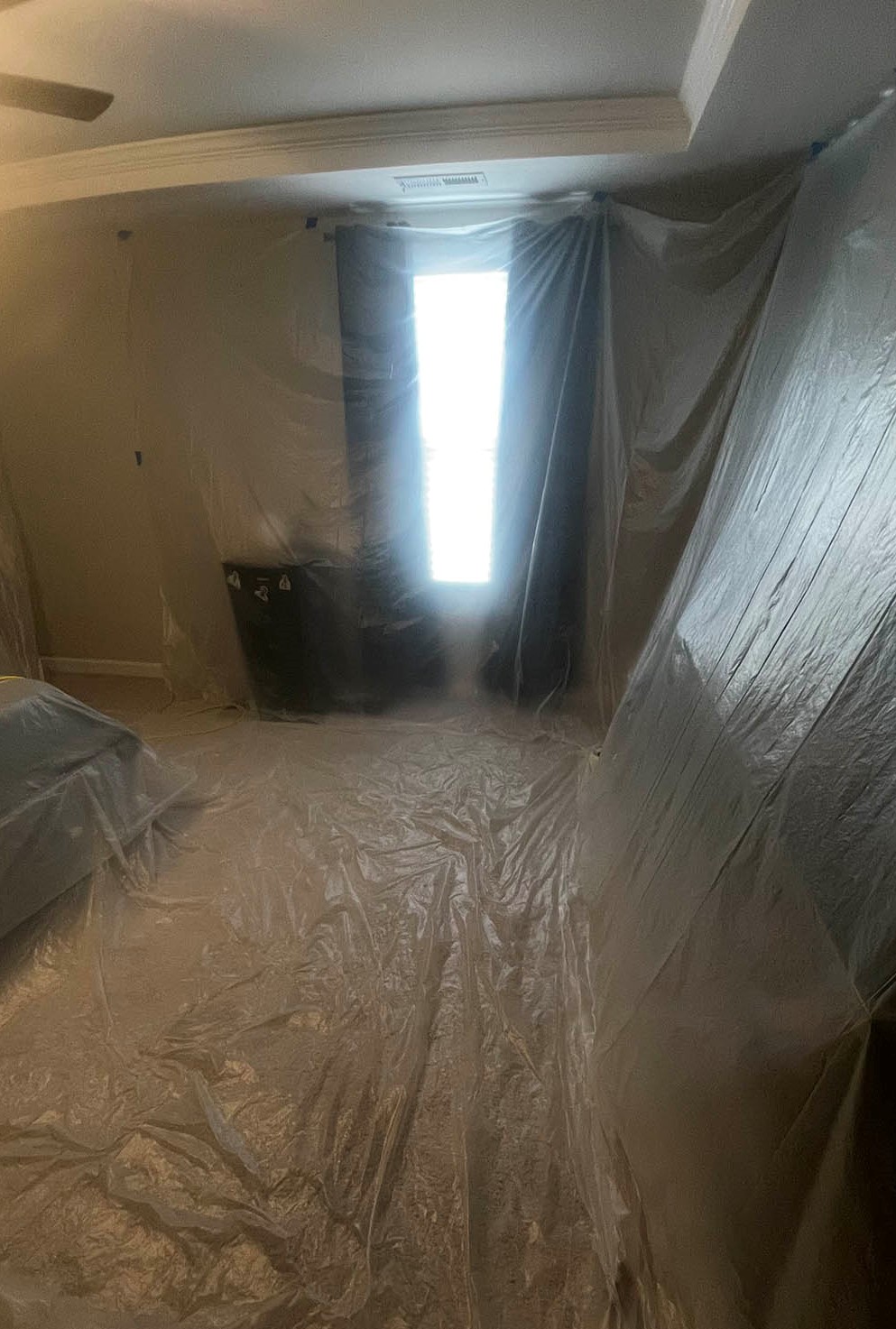 Plastic dust barrier in living room with extending poles